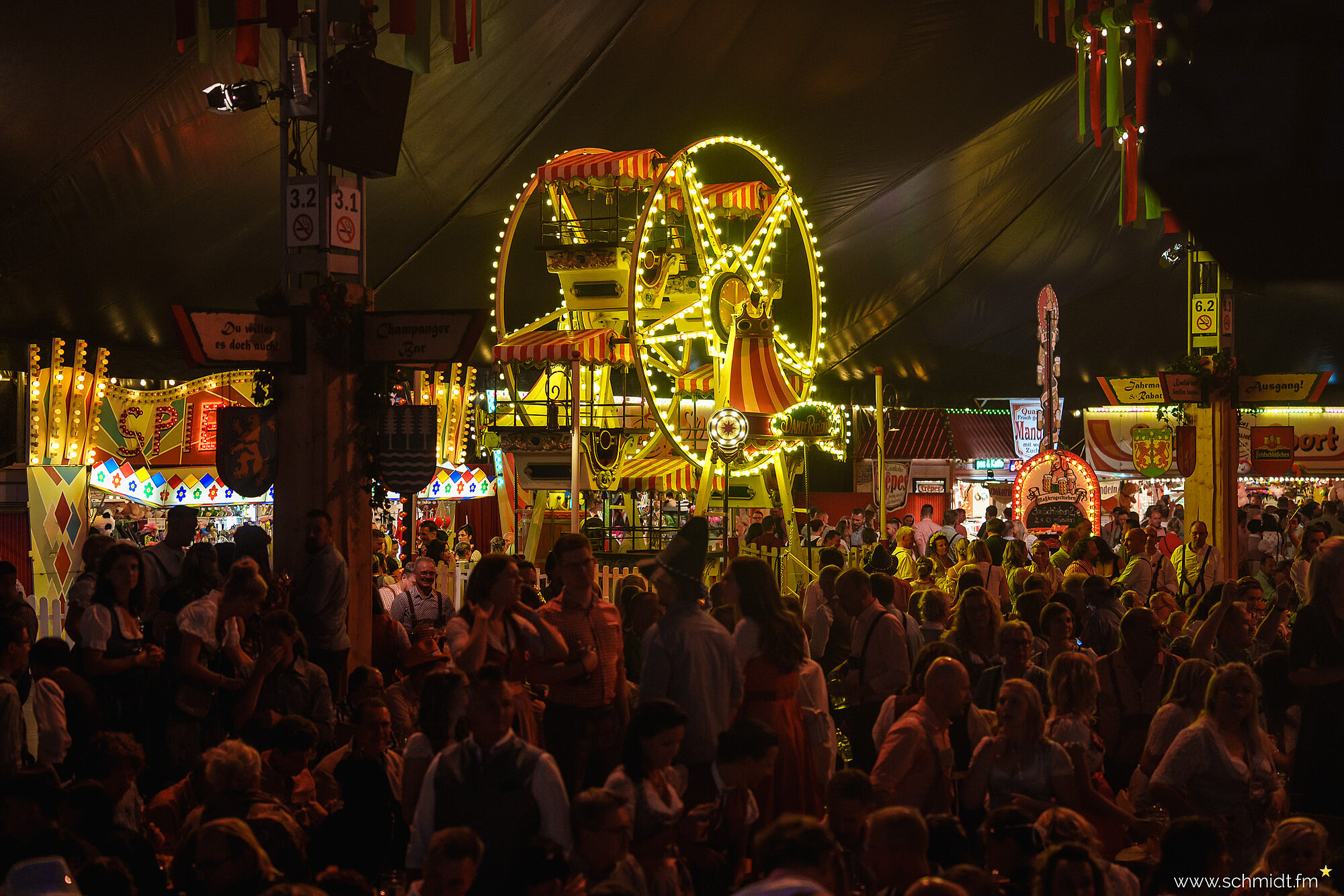 Das mit Menschen gefüllte Festzelt mit dem historischen Riesenrad im Hintergrund