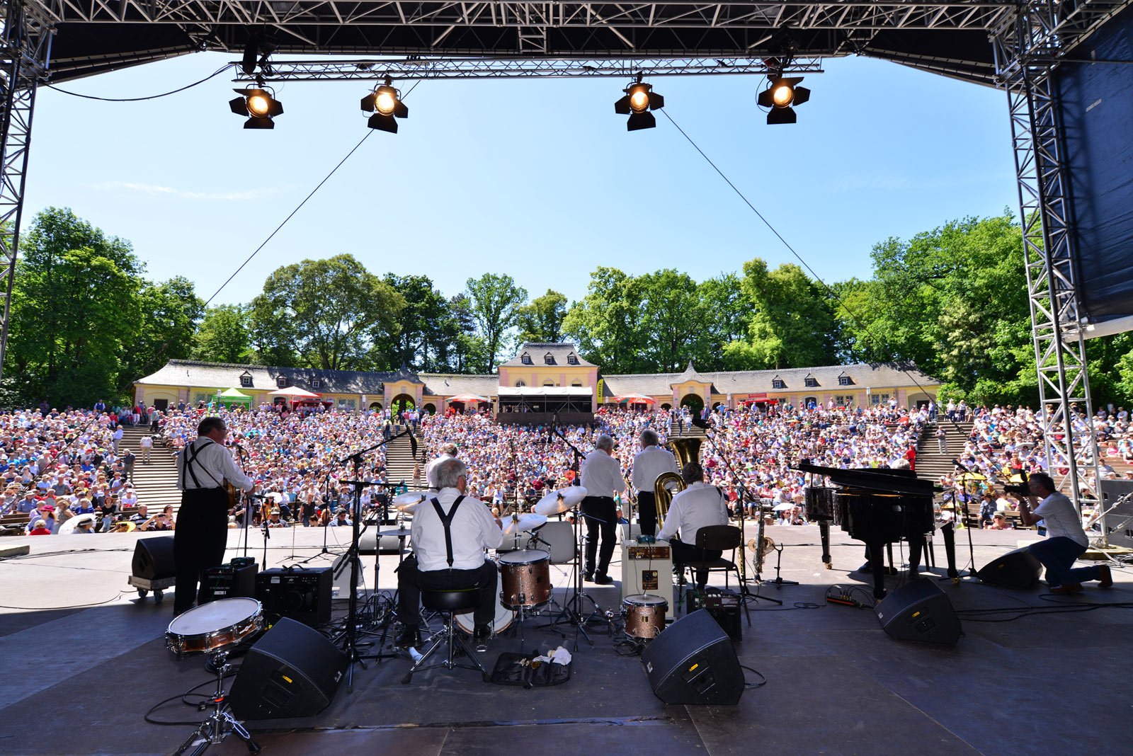 Eine Jazzband spielt vor einem großen Publikum in der Jungen Garde Dresden, das Foto zeigt die Band von hinten und fokussiert die lauschenden Zuschauer