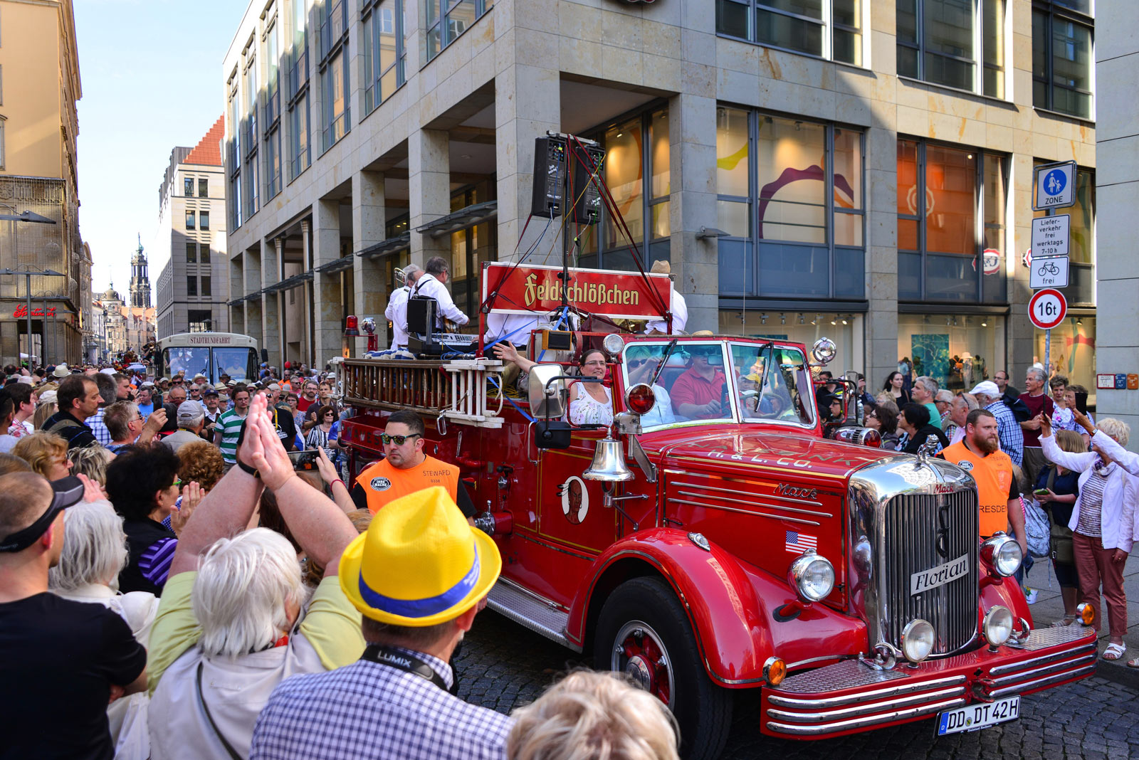 Eine alte rote Feuerwehr mit Feldschlößchen Logo startet die Dixielandparade durch die Dresdner Altstadt bejubelt von zahlreichen Besuchern