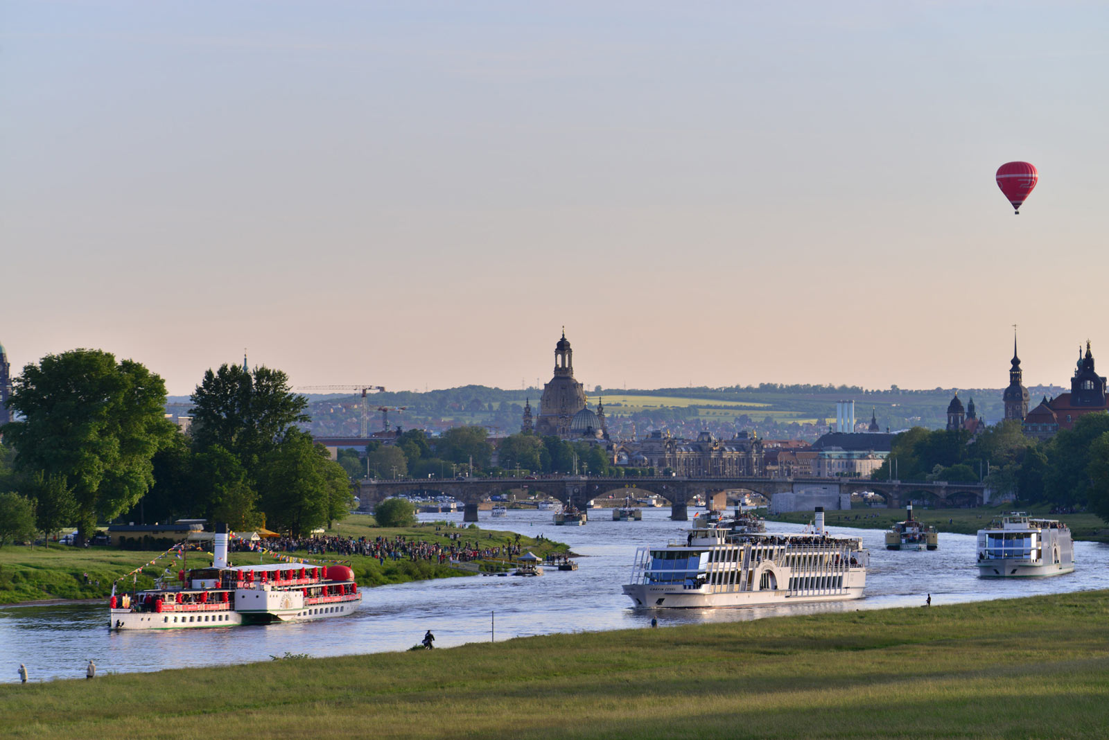 Atmosphärisch bei Sonnenuntergang führt der Dampfer mit Feldschlößchen Ballons und Bannern die Riverboatshuffle auf der Elbe an. Im Hintergrund erstrahlt die Frauenkirche und Carolabrücke im Panorama 