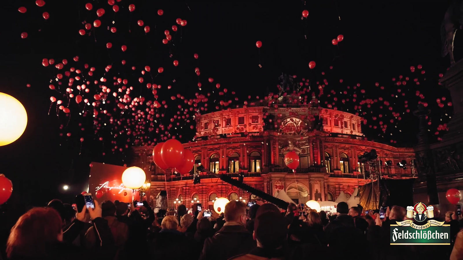 Großes Freiluft-Event vor der beleuchteten Semperoper in Dresden: Hunderte rote Luftballons schweben über dem Platz in den Nachthimmel